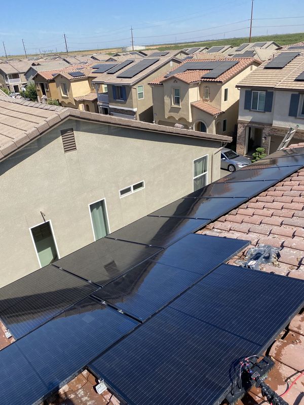 Freshly cleaned solar panels on a tile roof in a Central Valley neighborhood